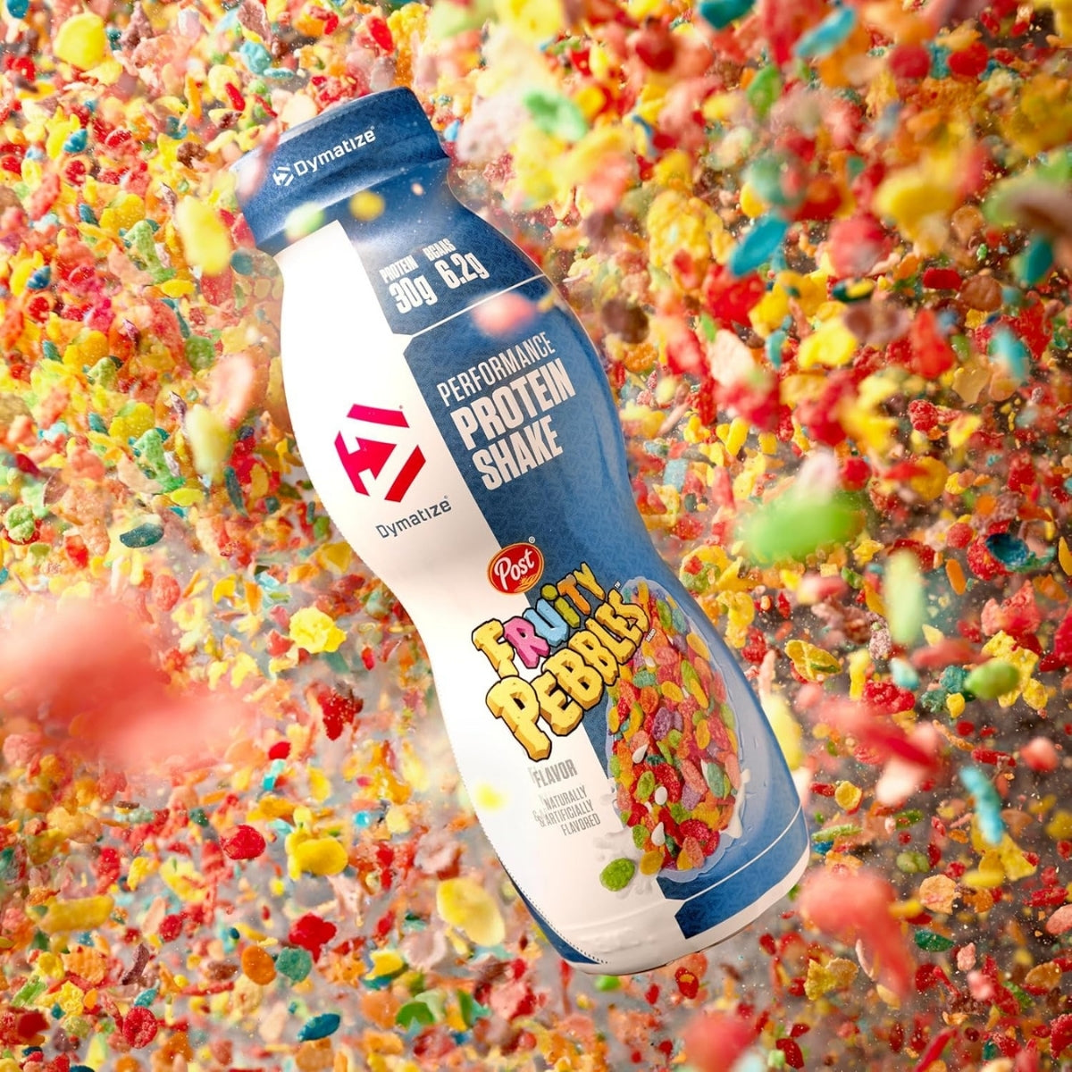 Dynamite Performance Protein Shake bottle with Fruity Pebbles flavor against a colorful background of Fruity Pebbles cereal pieces.